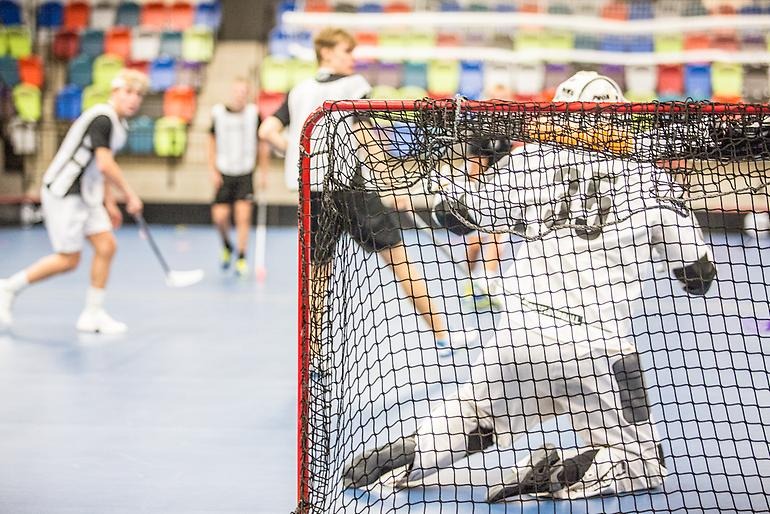 Innebandymålvakt försöker rädda bollen.