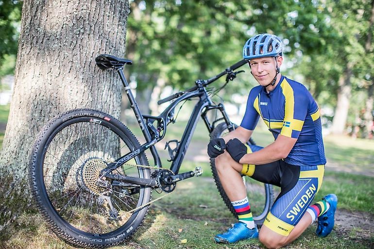 Ung cyklist framför sin racer.