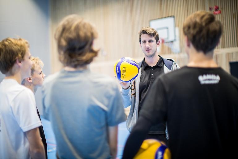 Unga volleybollspelare lyssnar andäktigt på sin tränare.